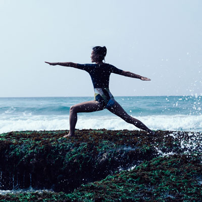 woman-practising-yoga-on-rocks